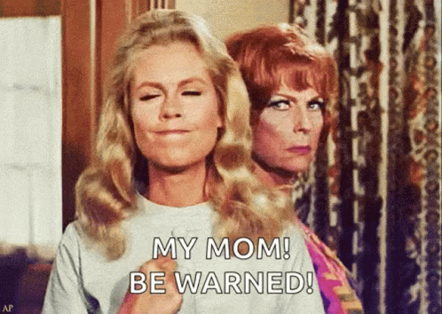 Two Women Are Standing Next To Each Other With One Saying My Mom Be Warned GIF