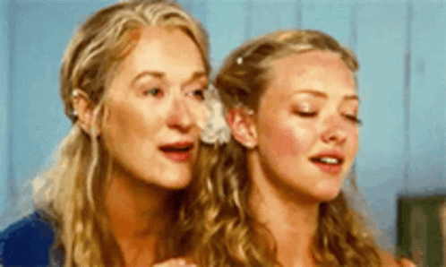 Two Women Are Standing Next To Each Other With Their Eyes Closed And Their Mouths Open . GIF
