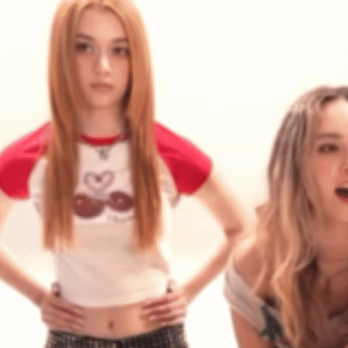 Two Women Are Standing Next To Each Other With Their Hands On Their Hips .. GIF