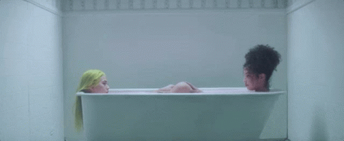 Two Women Are Taking A Bath In A Bathtub . GIF
