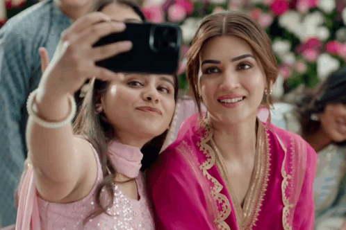 Two Women Are Taking A Selfie With A Phone GIF