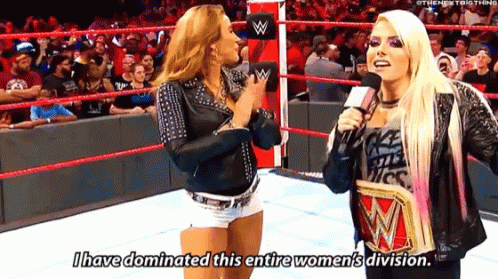 Two Women Are Talking In A Wrestling Ring And One Of Them Is Holding A Wrestling Championship . GIF