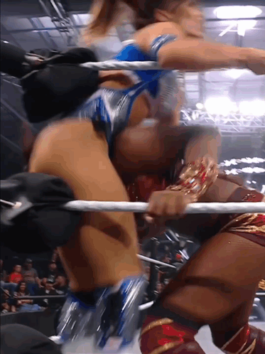 two women are wrestling in a ring and one of them has a bracelet on her wrist