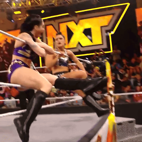 Two Women Are Wrestling In A Ring With The Word Nxt Behind Them GIF