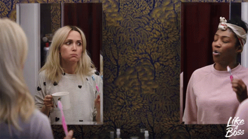 Two Women Brushing Their Teeth In Front Of A Mirror With Like A Boss Written On The Bottom GIF