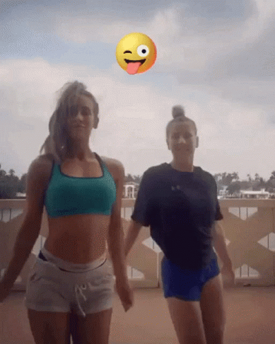 Two Women Dancing Before Smiley Face Sticking Tongue Out
