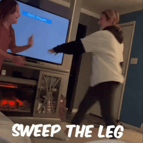 Two Women Dancing In Front Of A Tv With The Words Sweep The Leg GIF