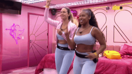 Two Women Dancing in Room With Pink Walls and Beds