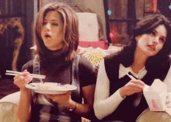 Two Women Eating Food with Chopsticks