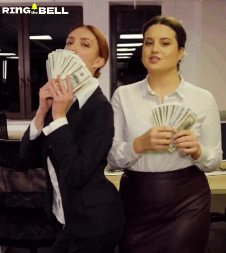 Two Women Holding Stacks Of Money With Ring The Bell Written On The Bottom GIF