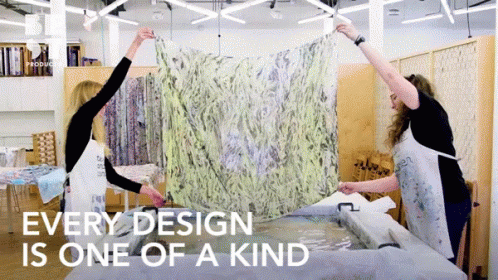 Two Women Holding Up A Piece Of Fabric With The Words " Every Design Is One Of A Kind " GIF