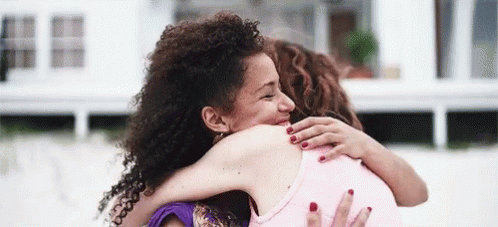 Two Women Hugging and Smiling on Beach