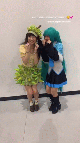 Two Women in Costumes Standing Next to Each Other