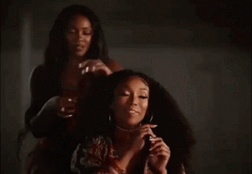 Two Women In Dark Room One Holding Hair GIF