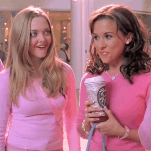 Two Women in Pink Sweaters One Holding Starbucks Coffee