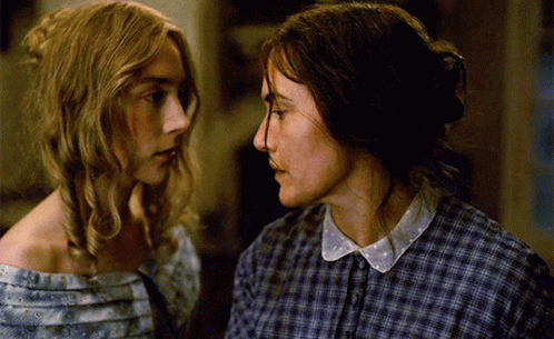 Two Women In Plaid Shirts Are Looking At Each Other GIF