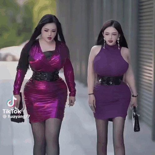 Two Women in Purple Dresses Walking