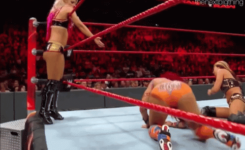 Two Women in Wrestling Ring One Kneeling