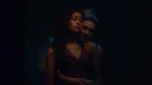 Two Women Kissing in Dark Room With Painting