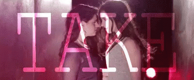 Two Women Kissing in Front of Pink Take