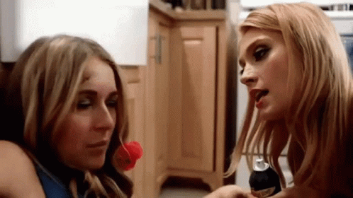 Two Women Kitchen One With Soda Can In Mouth GIF