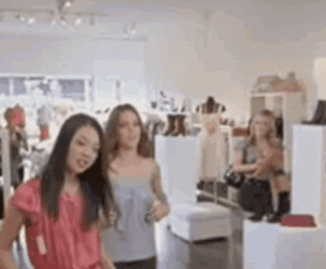 Two Women Looking At Clothes In Store GIF
