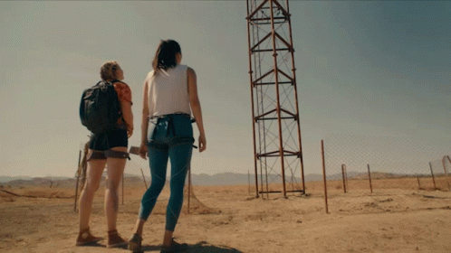 Two Women Looking At Tower In Field GIF