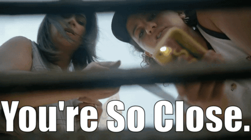 Two Women Looking Through A Window With The Words " You 'Re So Close " On The Bottom GIF
