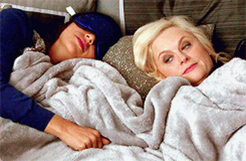 Two Women Lying in Bed Under Blanket