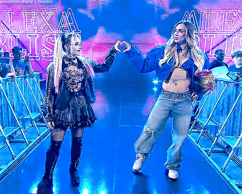 Two Women Making Heart Shape In Front Of Lexa Blitz Sign GIF