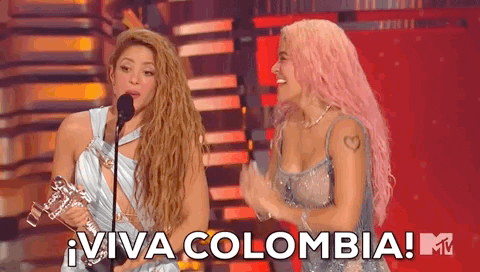 Two Women on Stage with Microphone and Trophy