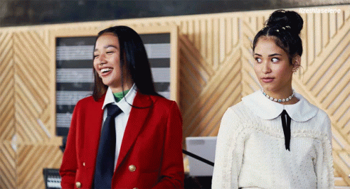 Two Women One In Red Coat Standing Together GIF