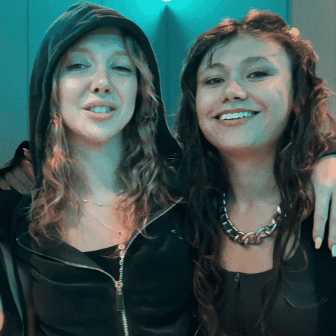 Two Women Posing, One in Black Hoodie