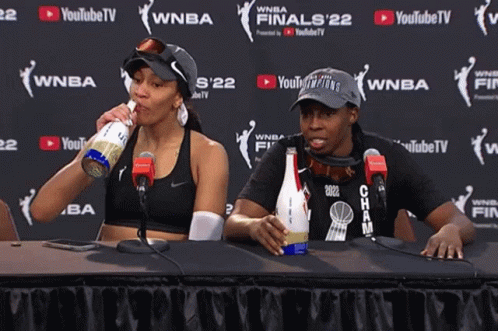 Two Women Sit At A Table In Front Of A Youtube Tv Sign GIF