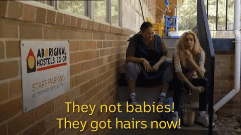 Two Women Sit On Stairs Next To A Sign That Says Staff Parking GIF
