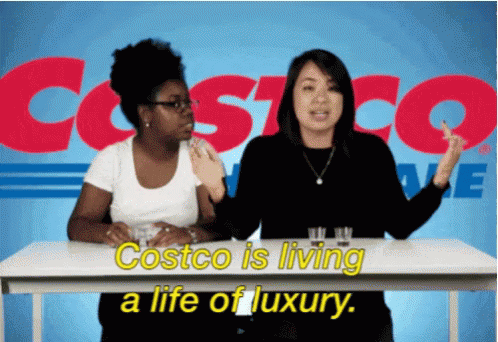 Two Women Sitting At A Table With Costco Written In The Background GIF