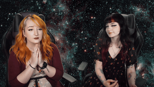 Two Women Sitting Hands Folded in Front of Galaxy Background