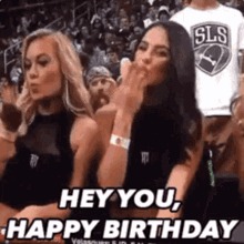 Two Women Sitting in Basketball Stands One Blowing a Kiss