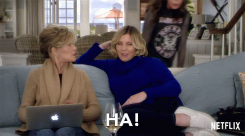 Two Women Sitting On A Couch With A Netflix Logo On The Bottom Right GIF