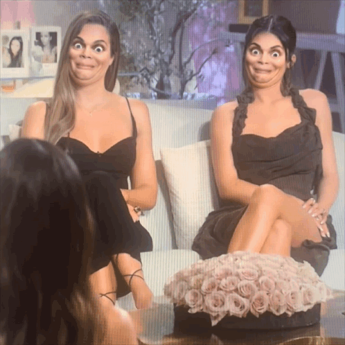 Two Women Sitting On A Couch With Their Legs Crossed Making Funny Faces GIF