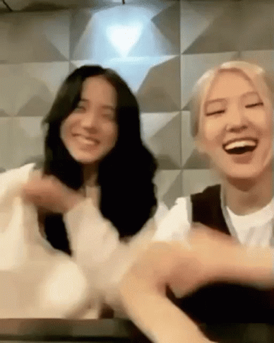 Two Women Sitting On Table Smiling GIF