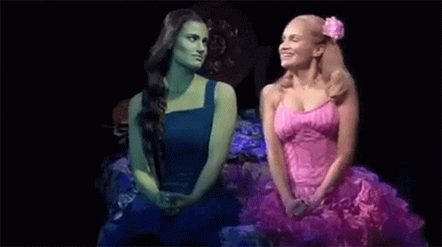 Two Women Sitting Together On Stage GIF