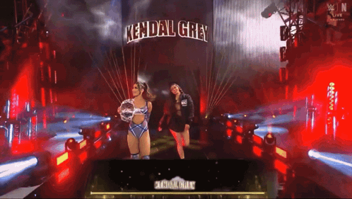 two women standing in front of a sign that says kendal grey on it