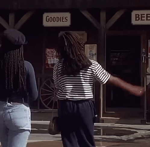 Two Women Standing In Front Of A Store Called Goodies And Beer GIF