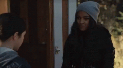 Two Women Standing In Front Of Door Talking GIF