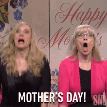 Two Women Standing in Front of Happy Mothers Day Sign