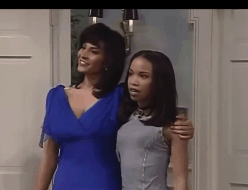 Two Women Standing Next To Each Other One In A Blue Dress GIF