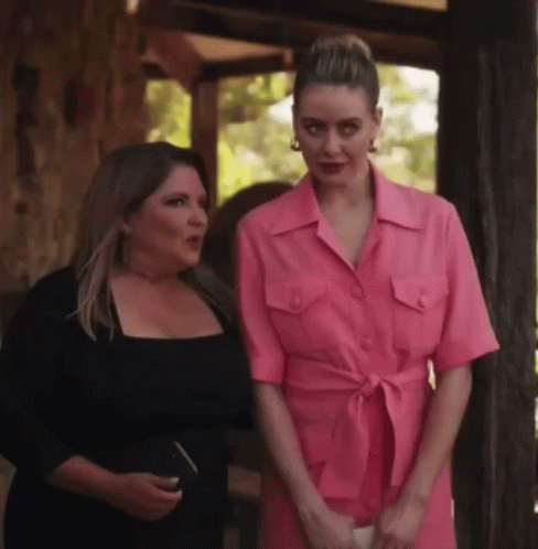 Two Women Standing Next to Each Other One in Pink Dress