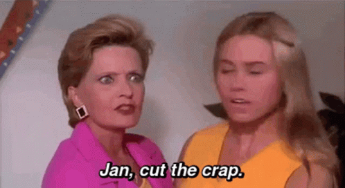 Two Women Standing Next To Each Other Talking