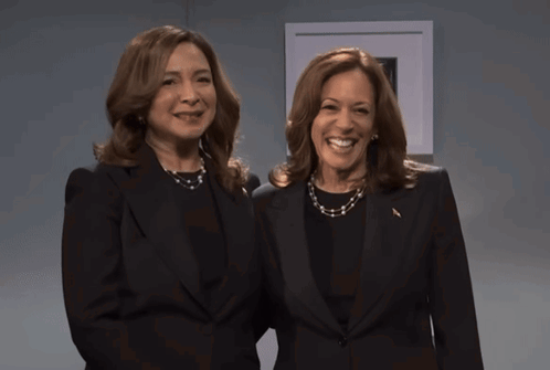 Two Women Standing Next To Each Other Wearing Black Suits GIF
